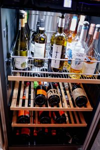 Open wine bottles stored vertically for short term storage, while long term storage is horizontal. 
